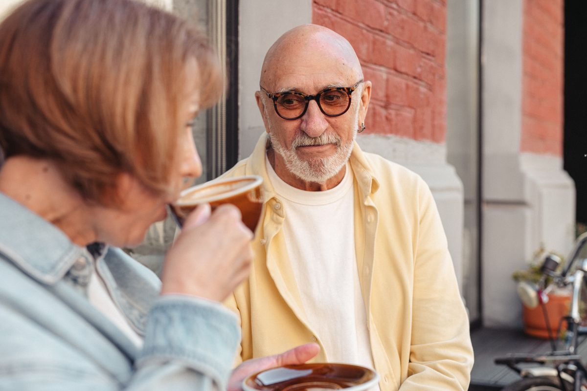 Une femme et un homme d’une soixantaine d’années prennent un café à une terrasse
