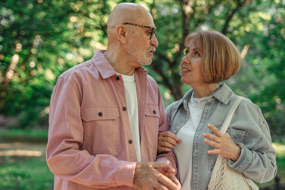 Un couple de seniors discute dans un parc